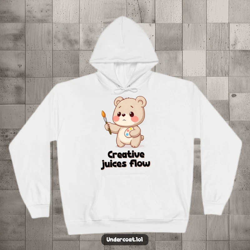 Funny bear artist hoodie, a playful bear artist balancing art supplies with intense concentration, warm and cozy.