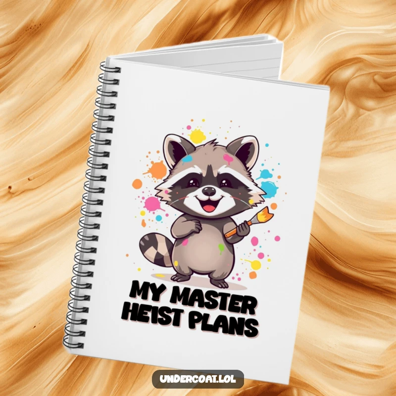 Funny raccoon notebook with a joyful raccoon splattering vibrant paint with a brush, perfect for jotting down messy ideas.